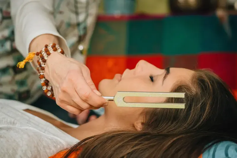 A music therapist working with a patient in a clinical setting