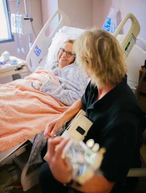 Harmony & Healing musician playing guitar for a smiling hospital patient
